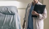 medical-professional-in-scrubs-holding-clipboard-and-pen