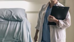 medical-professional-in-scrubs-holding-clipboard-and-pen
