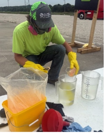 Wellington technician mixing disinfectant in measuring containers outdoors